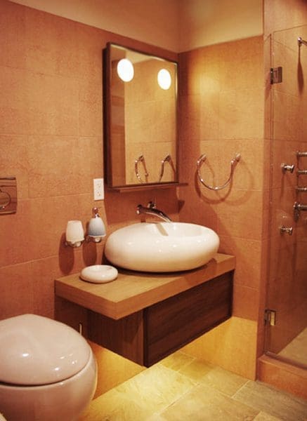 An orange-themed luxury bathroom with a floating vanity.