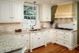 A transitional-styled kitchen remodel with a beautiful range hood and custom cabinetry.