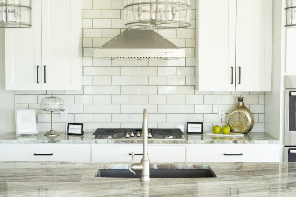 White Subway Tile in a white kitchen with beige countertops.