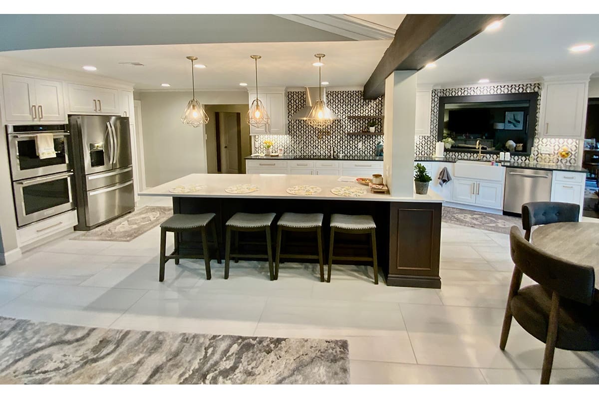 A luxurious, large kitchen remodel featuring pendant lighting and large format marble tiles.